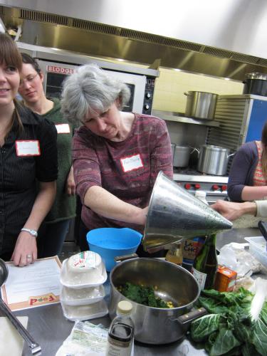 Adding steamed spinach to dumpling filling