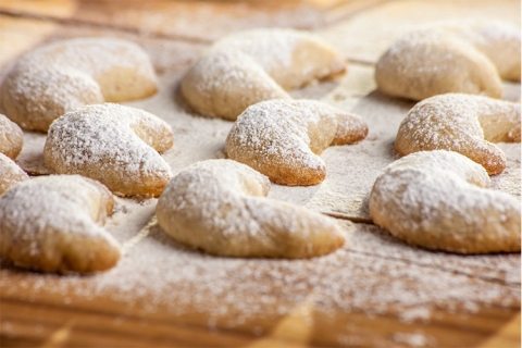crescent cookies with powdered sugar on a wooden board