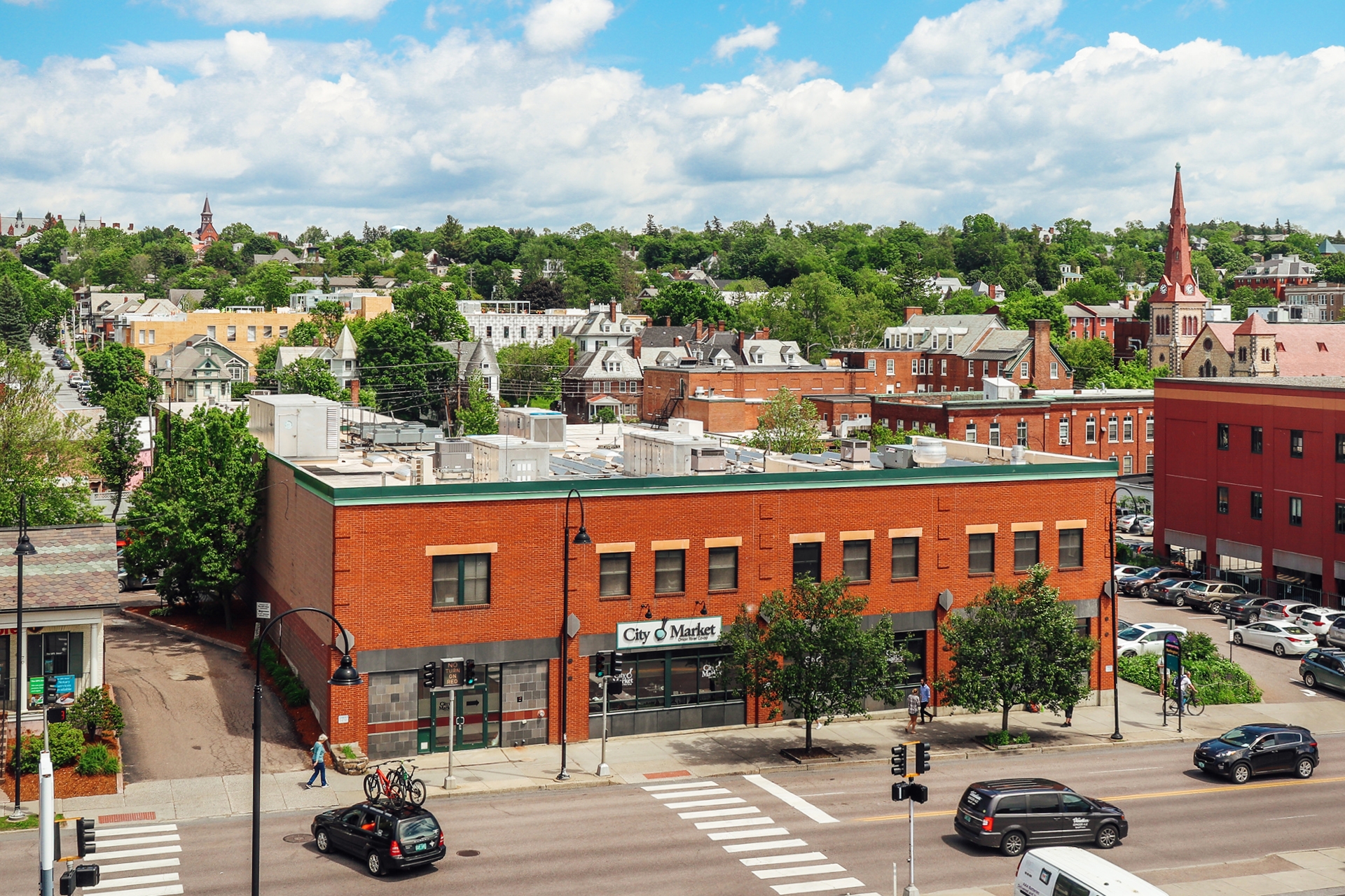 An exterior view of City Market's Downtown store location with the surrounding cityscape 