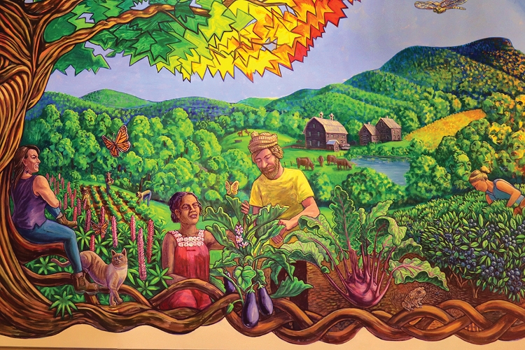 A mural of an agricultural landscape with people working in a field in the center and a person resting under a large tree on the left.