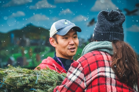 John Tashiro passing a tree to a colleague during the COTS Tree Sale tree delivery.