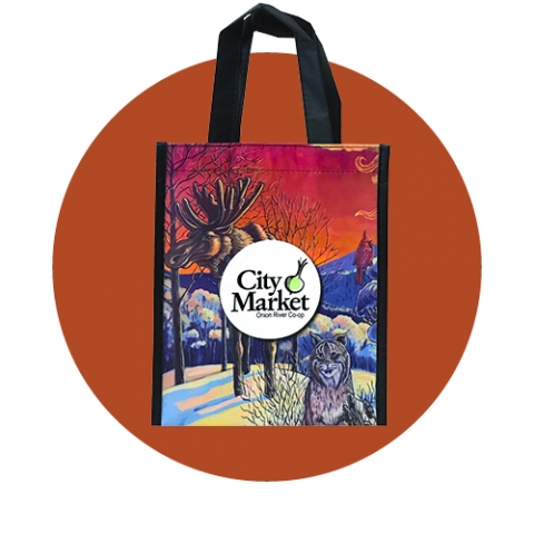 A City Market reusable tote bag in front of a rust red circle