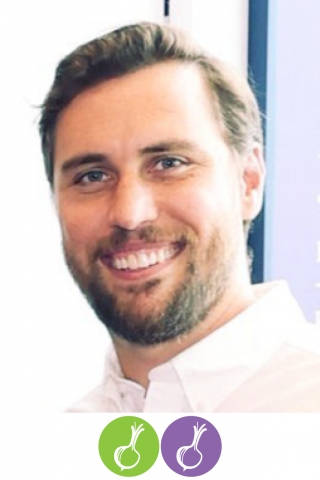 A photo of a person from the shoulders up. The person is wearing a white button-down shirt and standing in front of a white, teal and lavender wall. Below the photo are two circles, one green and one purple. Each circle has a white silhouette of an onion inside it.