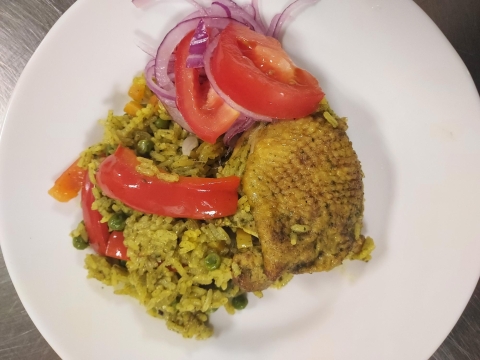 a white plate with chicken, rice, and a tomato and onion salad