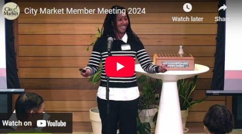 a photo of a woman standing at a podium at City Market's 2024 Member Meeting