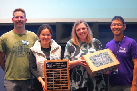 the 2025 Community Service Award winner Bianka Cimrin stands next to Board members and John Tashiro, City Market's GM
