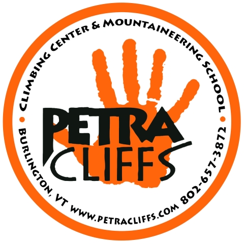 The words Petra Cliffs inside an orange circle and overlaying an orange handprint.