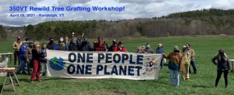 Group standing together outside behind a banner that reads, "One people, one planet"